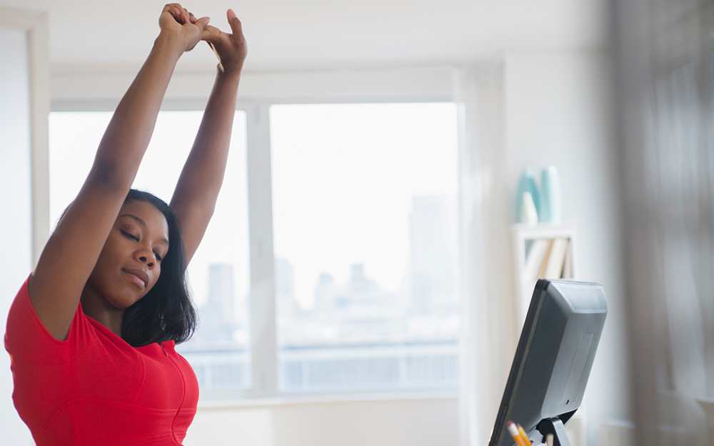 Woman stretching at her desk.