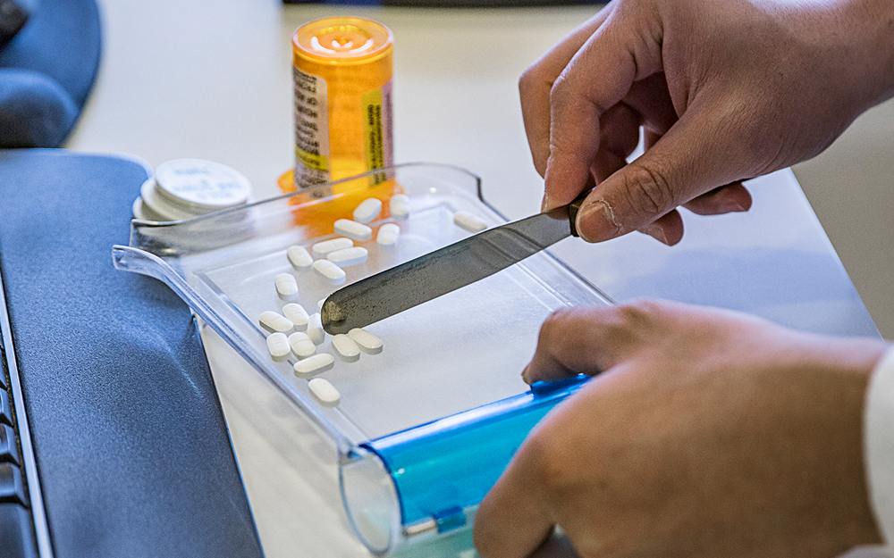 Pharmacist counting pills on a pill tray.