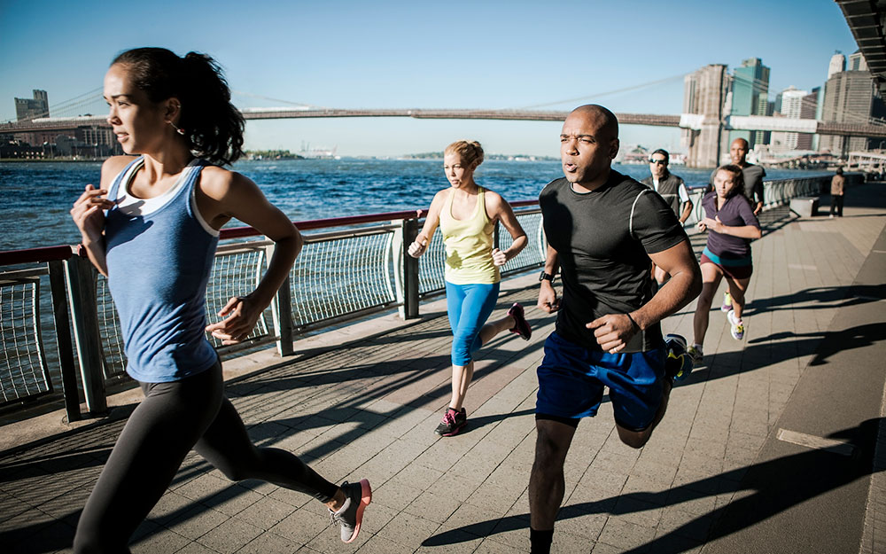 Group of men and women running outside.