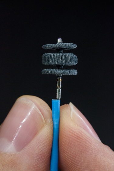 Person holding a tiny catheter.